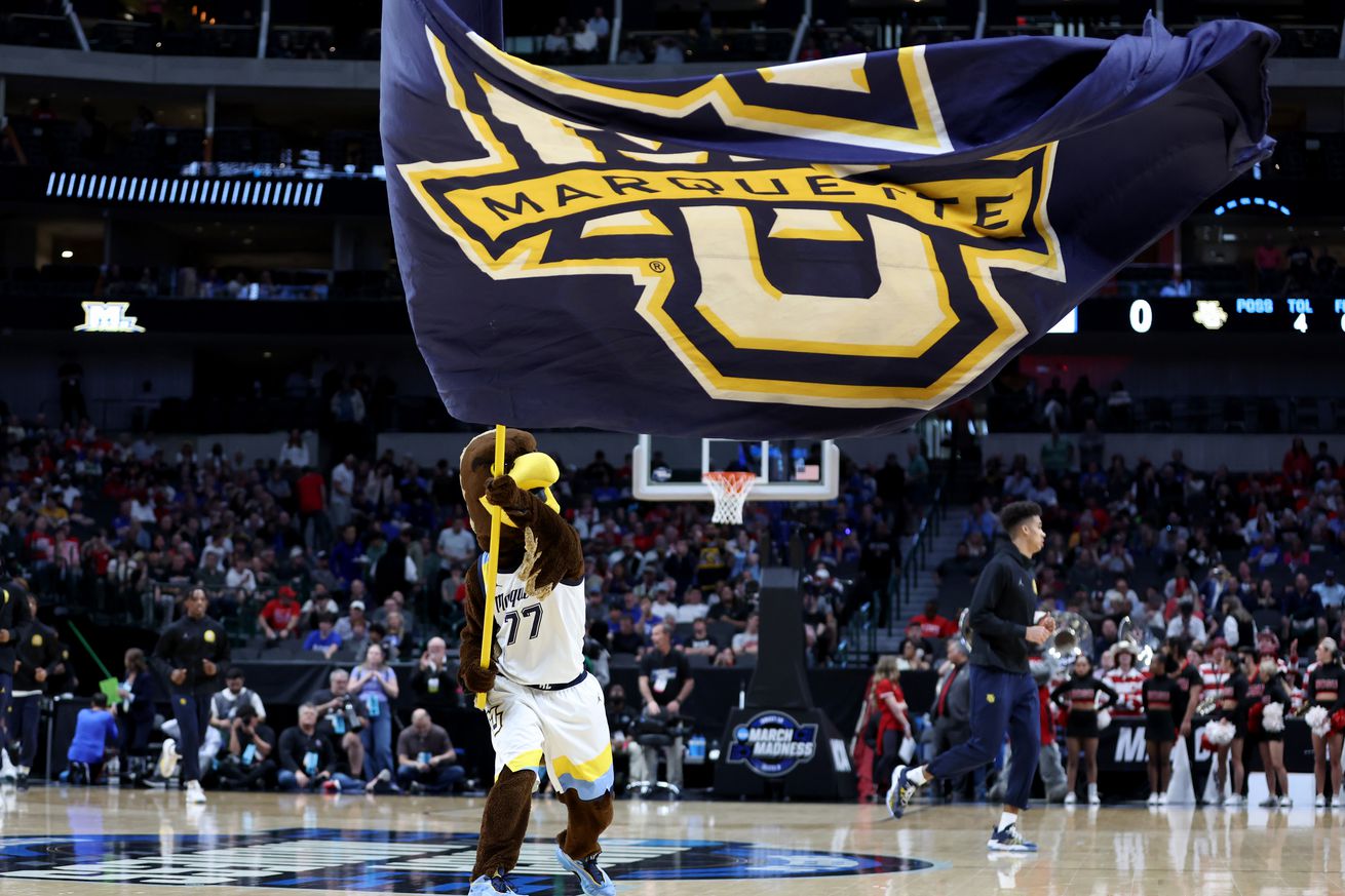 Marquette Golden Eagles mascot waves a flag before the first half in the semifinals of the South Regional against the North Carolina State Wolfpack of the 2024 NCAA Tournament at American Airlines Center.