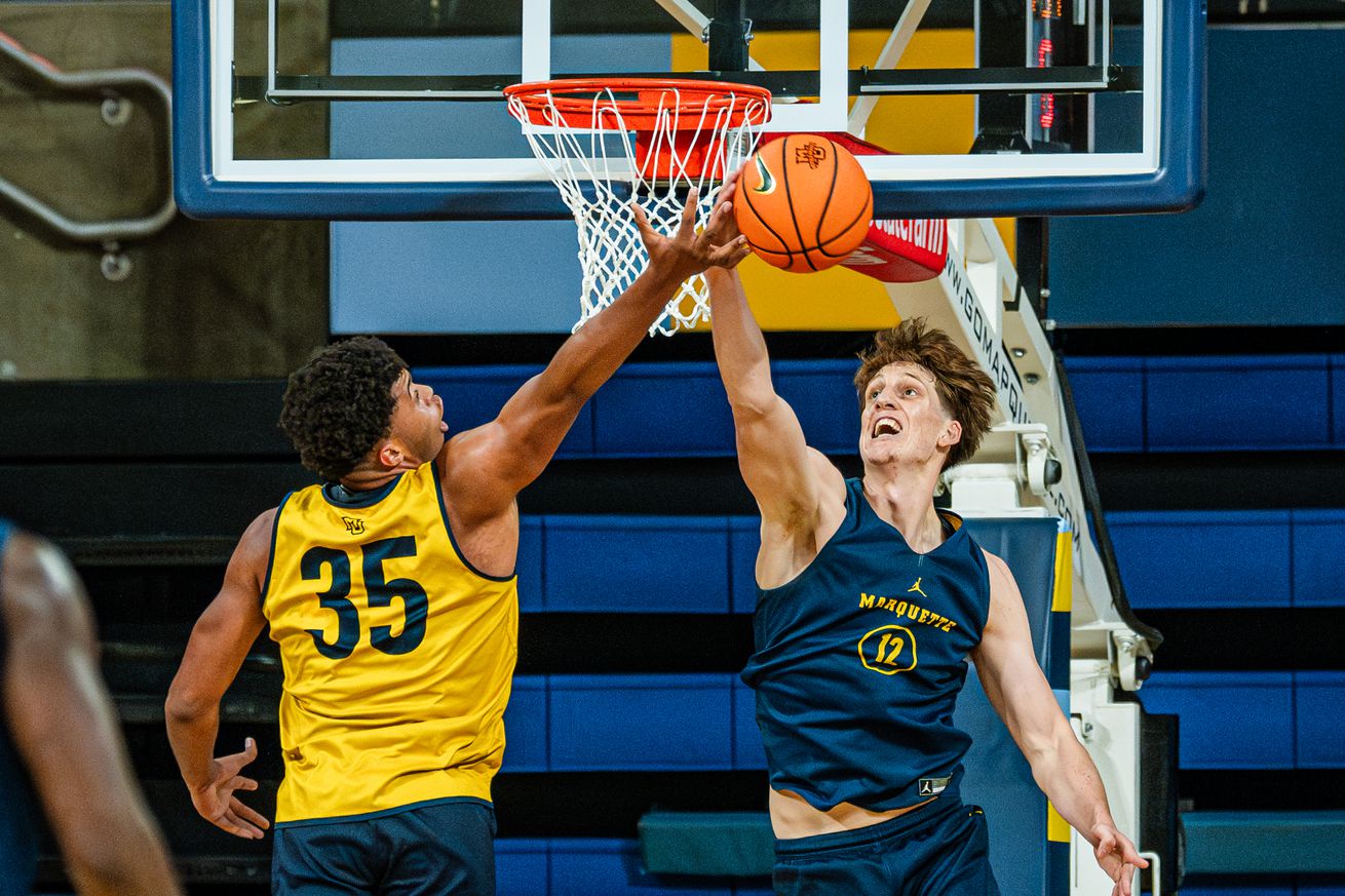 Ben Gold and Caedin Hamilton jousting at the rim in an open practice at the McGuire Center.