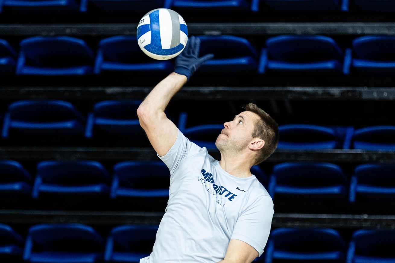 Marquette volleyball head coach Ryan Theis serving in practice.