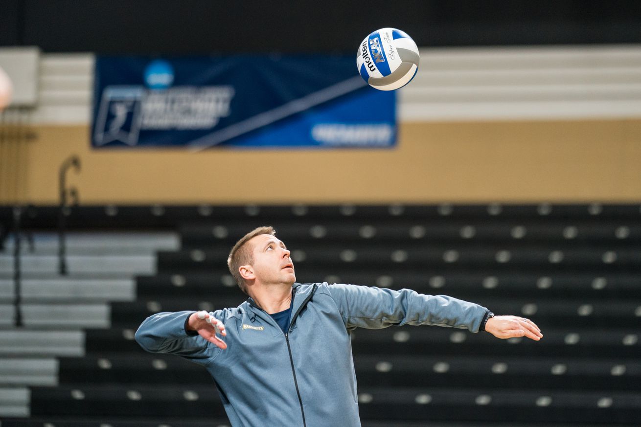 Marquette volleyball head coach Ryan Theis serving in practice.