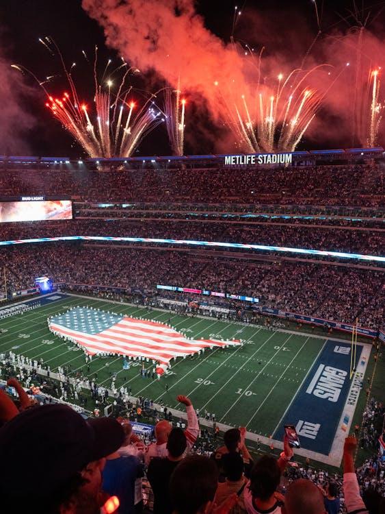 Free An exciting NFL match day at MetLife Stadium with fireworks and USA flag display. Stock Photo