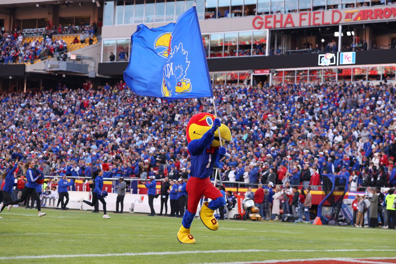 The Kansas Jayhawks mascot runs onto the field with a flag before a Big 12 game between the Colorado Buffaloes and Kansas Jayhawks on November 23, 2024 at GEHA Field at Arrowhead Stadium in Kansas City, MO.