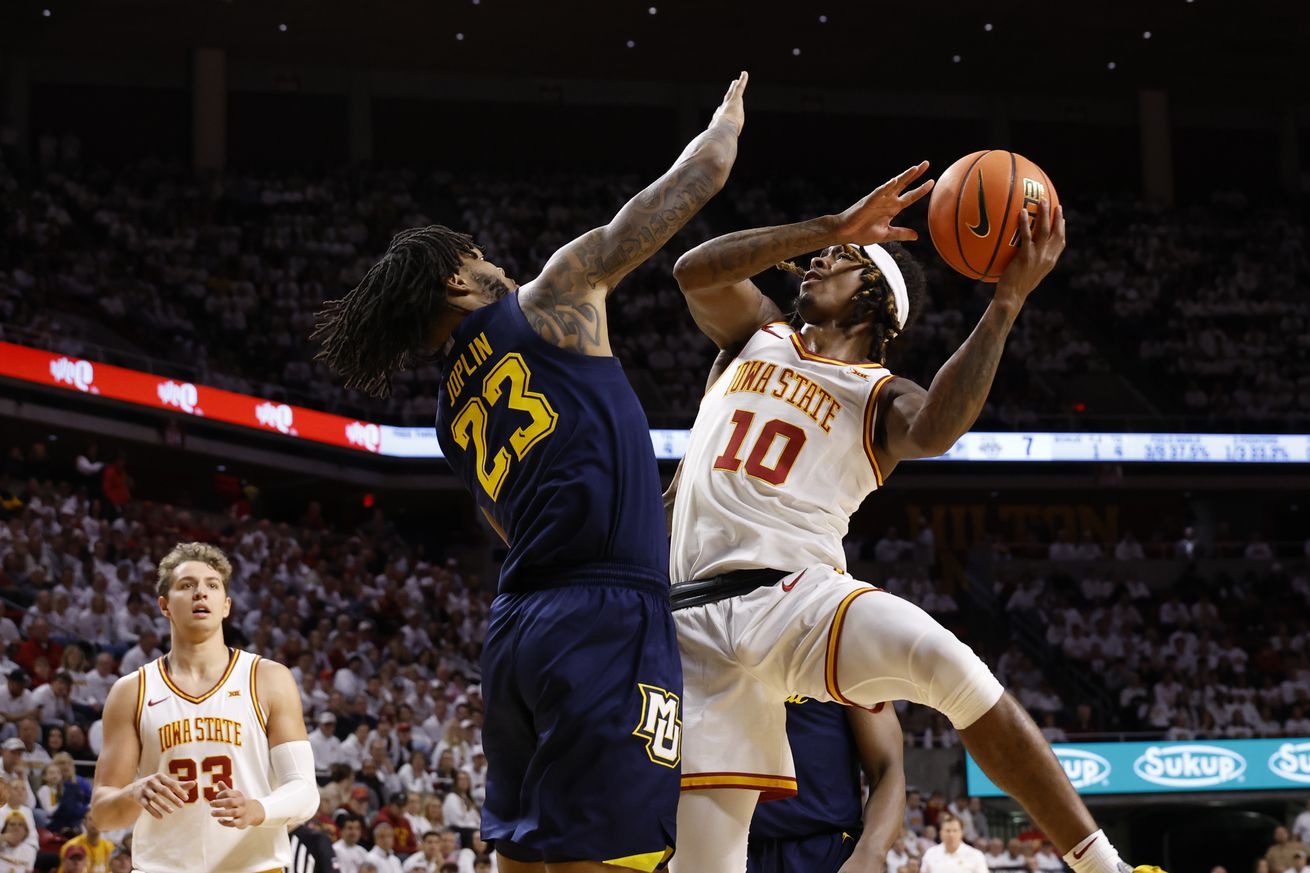 Keshon Gilbert #10 of the Iowa State Cyclones takes a shot as David Joplin #23 of the Marquette Golden Eagles blocks as Brandton Chatfield #33 of the Iowa State Cyclones watches on in the first half of play at Hilton Coliseum on December 4, 2024, in Ames, Iowa.