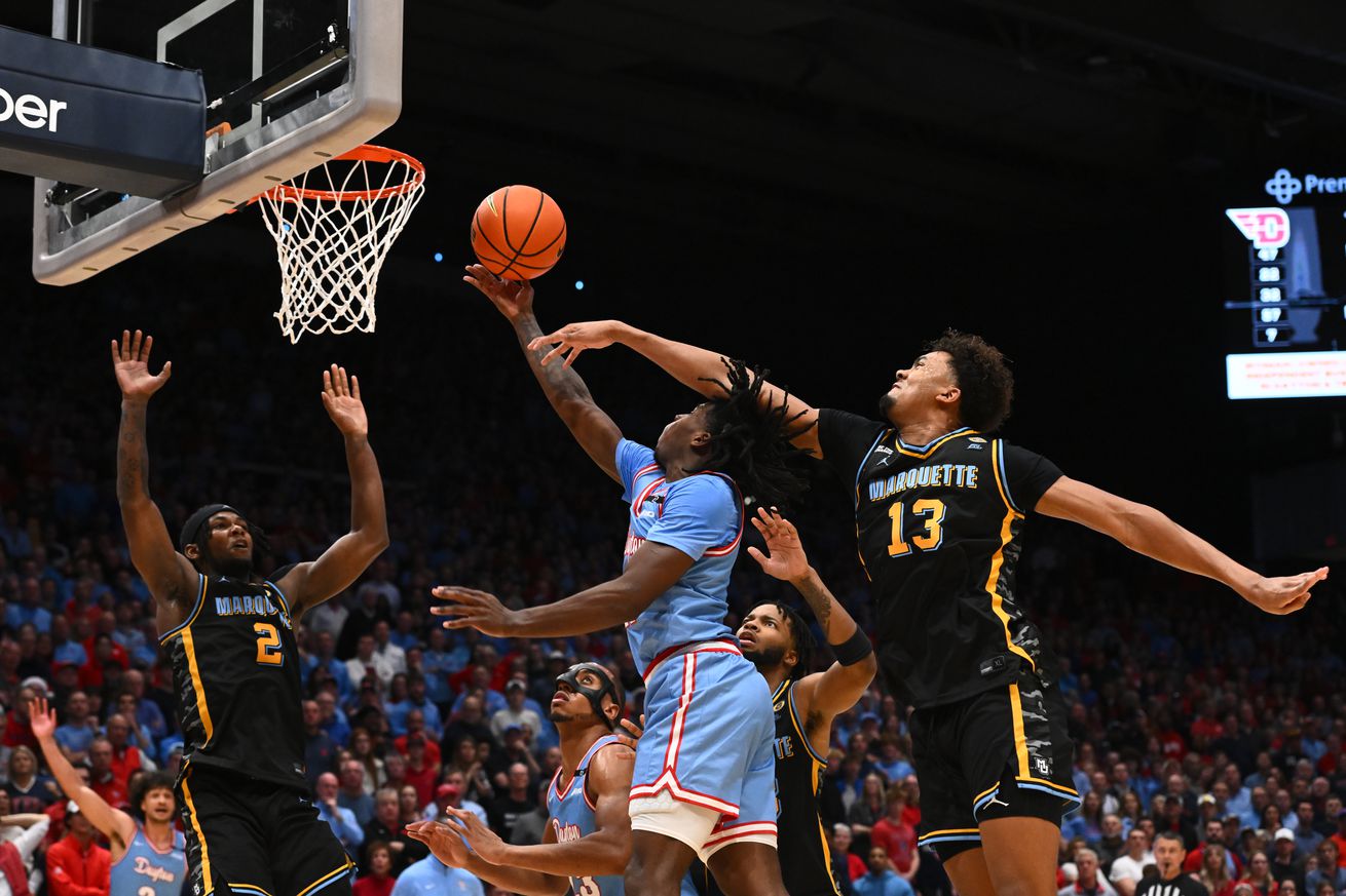 Malachi Smith #11 of the Dayton Flyers shoots the ball as Royce Parham #13 of the Marquette Golden Eagles defends during the second half of a game at UD Arena on December 14, 2024 in Dayton, Ohio.