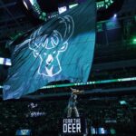 Milwaukee Bucks mascot Bango waves flag with the Milwaukee Bucks logo