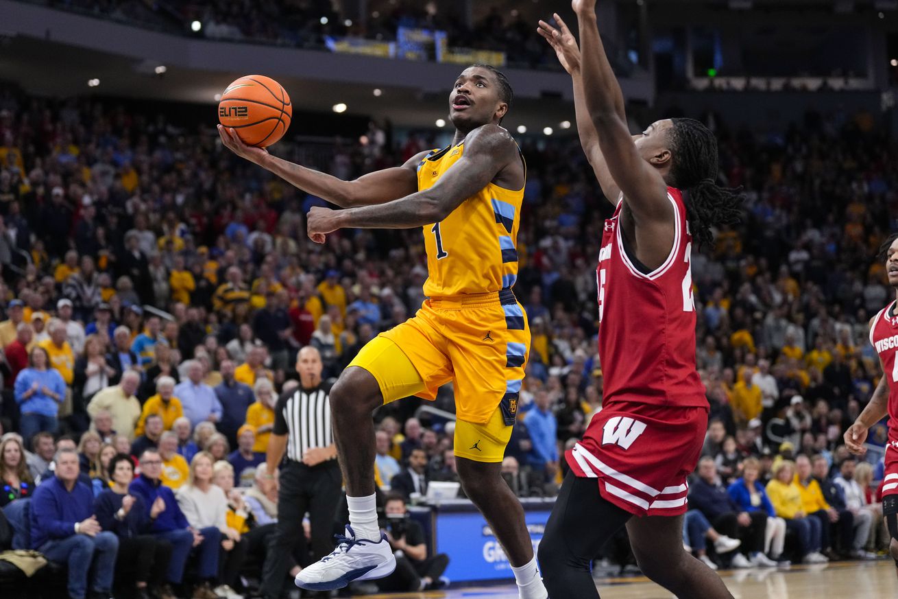 Marquette Golden Eagles guard Kam Jones (1) shoots against Wisconsin Badgers guard John Blackwell (25) during the second half at Fiserv Forum. 