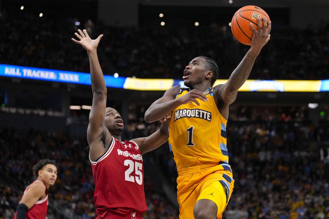 Marquette Golden Eagles guard Kam Jones (1) shoots over Wisconsin Badgers guard John Blackwell (25) during the second half at Fiserv Forum.