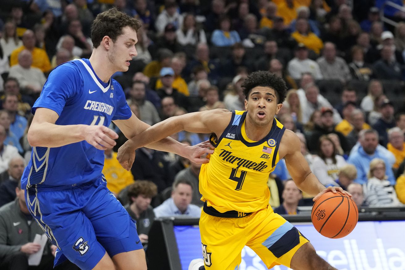 Stevie Mitchell #4 of the Marquette Golden Eagles dribbles the ball against Ryan Kalkbrenner #11 of the Creighton Bluejays during the first half at Fiserv Forum on January 03, 2025 in Milwaukee, Wisconsin.