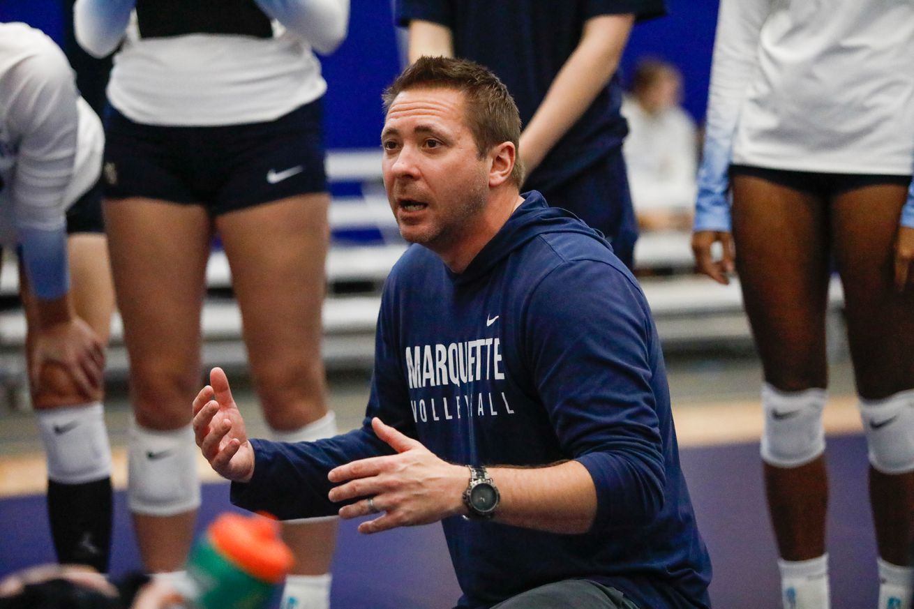 Marquette volleyball head coach Ryan Theis in a huddle with his team during a match against Pitt.