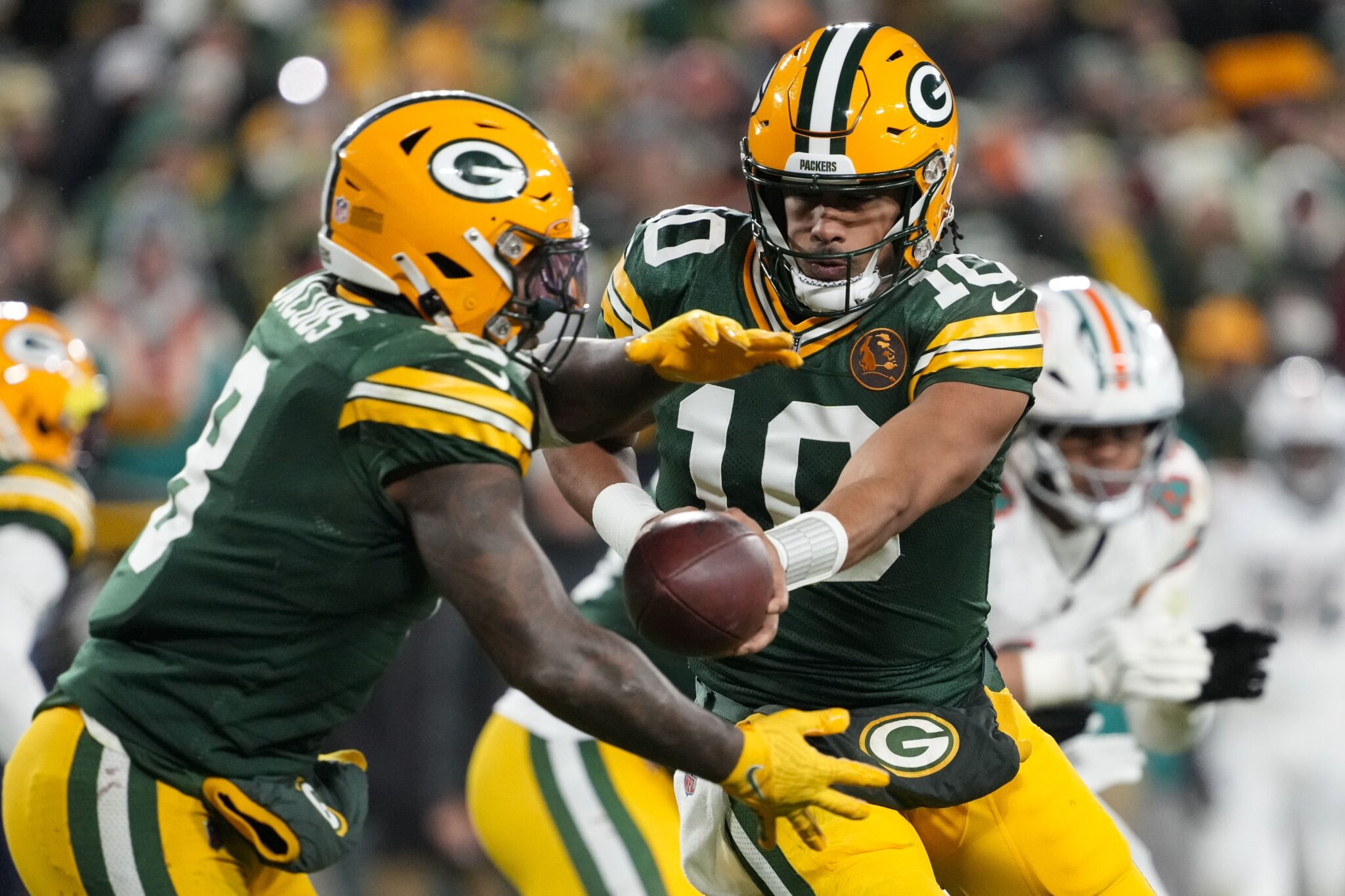 Jordan Love hands off to Josh Jacobs during Thanksgiving day Packers vs Dolphins game 2024