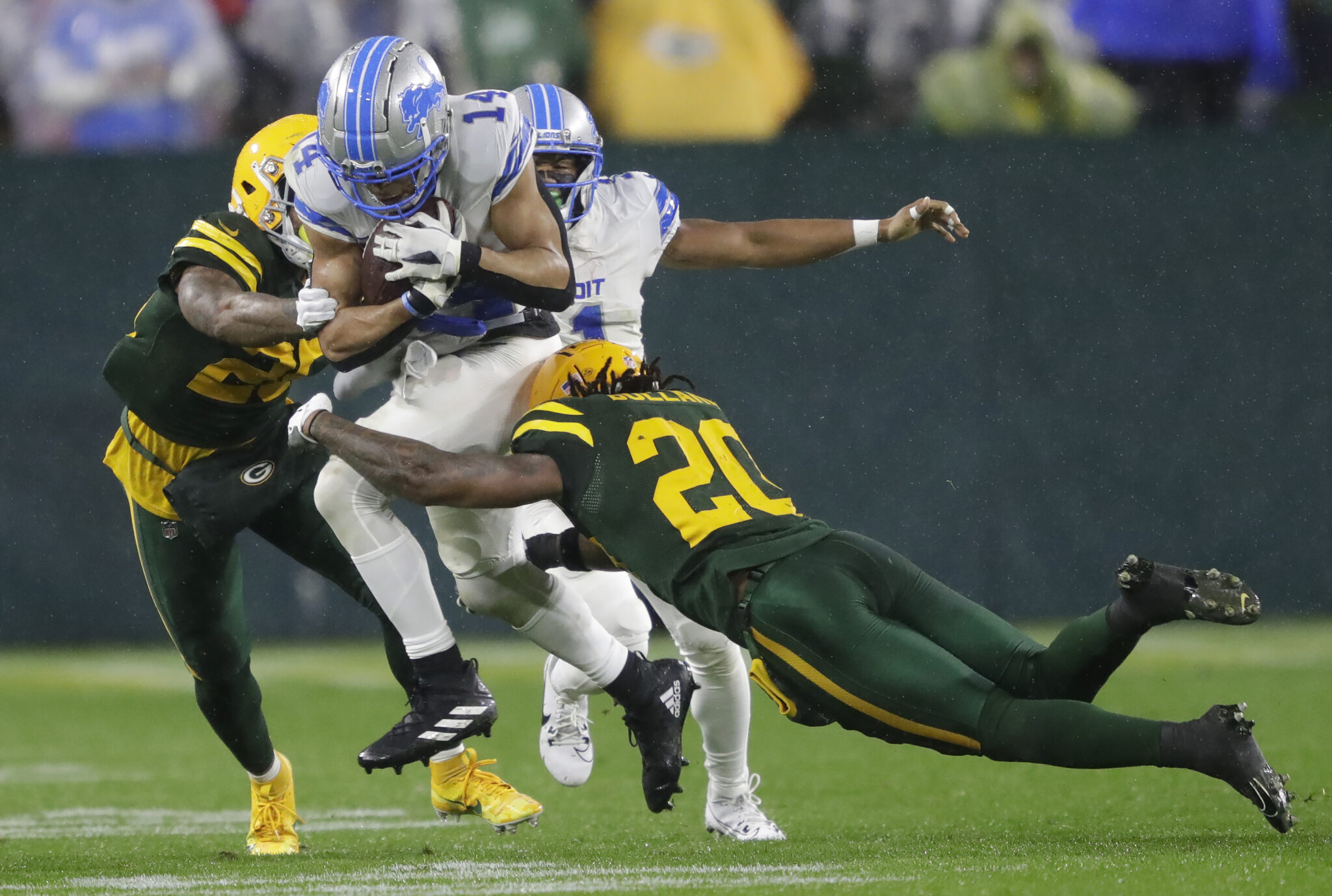 Detroit Lions wide receiver Amon-Ra St. Brown catches a pass against Green Bay Packers cornerback Keisean Nixon and safety Javon Bullard during their football game at Lambeau Field.