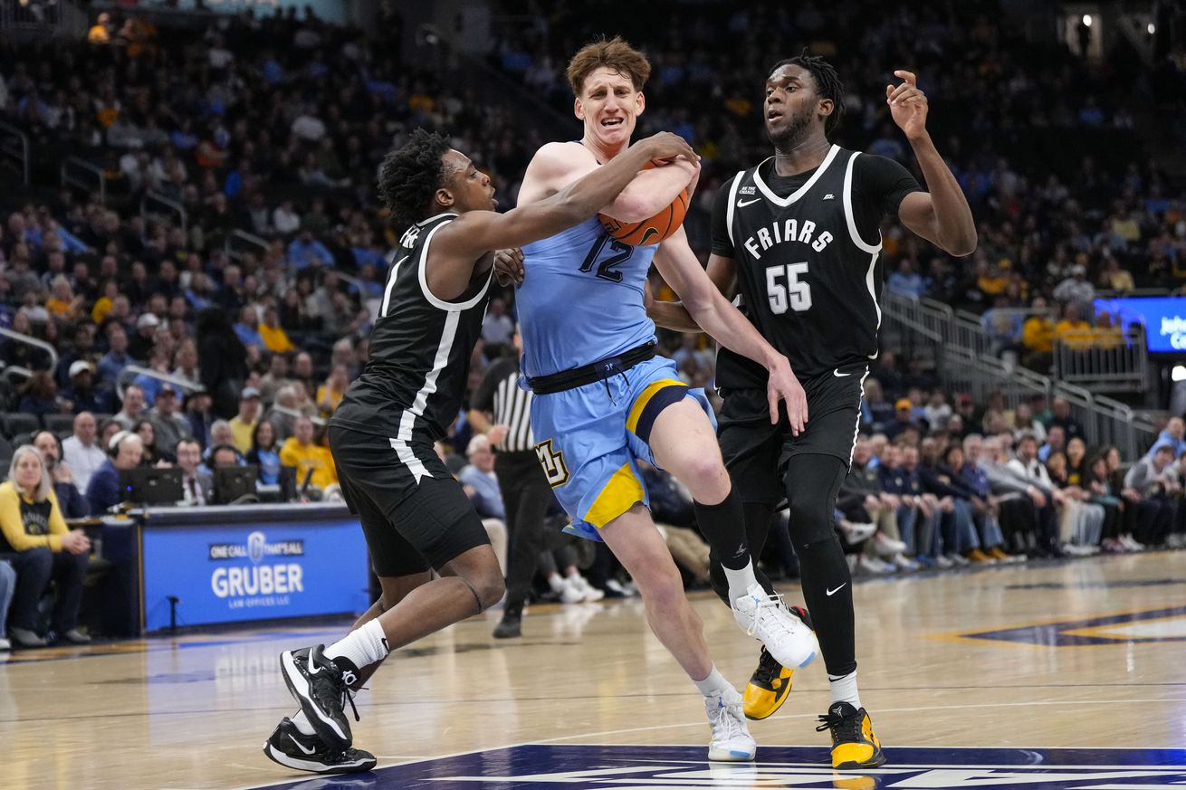 Marquette Golden Eagles forward Ben Gold (12) drives for the basket between Providence Friars guard Jayden Pierre (1) and forward Oswin Erhunmwunse (55) during the second half at Fiserv Forum.