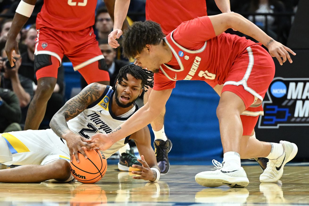 David Joplin #23 of the Marquette Golden Eagles and CJ Noland #0 of the New Mexico Lobos reach for a loose ball during the second half in the first round of the NCAA Men’s Basketball Tournament at Rocket Mortgage Fieldhouse on March 21, 2025 in Cleveland, Ohio.