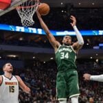 Feb 27, 2025; Milwaukee, Wisconsin, USA; Milwaukee Bucks forward Giannis Antetokounmpo (34) grabs a rebound against Denver Nuggets center Nikola Jokic (15) in the third quarter at Fiserv Forum. Mandatory Credit: Benny Sieu-Imagn Images