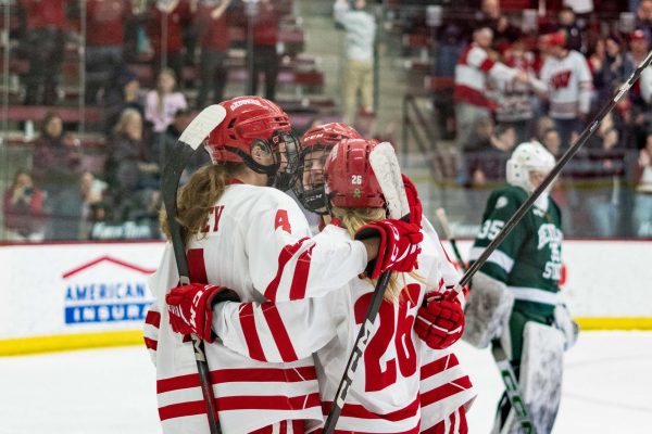 UW women's hockey players gather in a huddle. March 1, 2025.